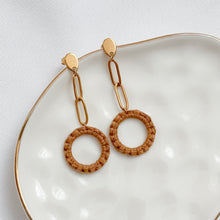 Load image into Gallery viewer, Pair of gold and brown earrings on a white plate