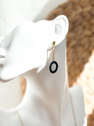 Black hoop earring on a white ear with a blurred background