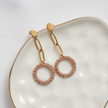 Load image into Gallery viewer, Pair of earrings with gold chains and pink circular pendants on a white dish.
