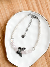 Load image into Gallery viewer, Bracelet with butterfly charm on a white plate
