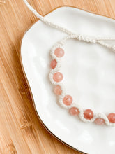 Load image into Gallery viewer, Bracelet with pink beads on a white plate on a wooden surface
