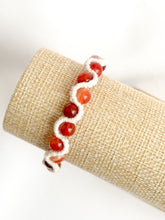 Load image into Gallery viewer, Bracelet with red beads on a beige roll of fabric
