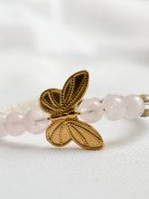 Load image into Gallery viewer, Bracelet with gold butterfly charm and clear beads on a white background

