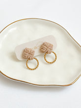 Load image into Gallery viewer, Macrame pair of earrings with gold hoops on a white dish
