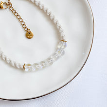 Load image into Gallery viewer, Bracelet with clear beads and gold accents on a white plate

