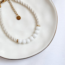 Load image into Gallery viewer, Bracelet with white beads and gold chain on a white plate
